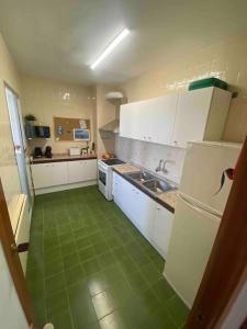 een keuken met witte kasten en een groene vloer bij Apartament Near The Beach in San Javier