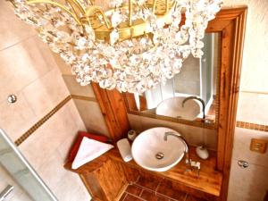a bathroom with a sink and a chandelier at Pension & Restaurant Atmosféra in Loket