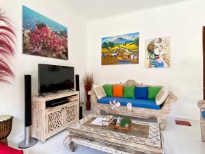 a living room with a couch and a tv at Timaya Villa in Legian