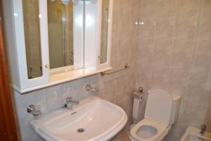 a bathroom with a sink and a toilet and a mirror at Inmoinsuas Plaza de Galicia 32 in Sarria