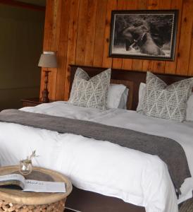 a bedroom with a large bed with white sheets and pillows at Barefoot Addo Elephant Lodge in Addo