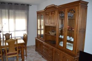 a large wooden cabinet in a dining room with a table at Inmoinsuas Plaza de Galicia 32 in Sarria