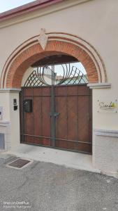 una gran puerta de garaje marrón con un arco sobre ella en Sienda Cesira, en Muravera