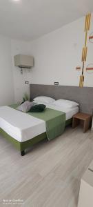 2 łóżka pojedyncze w pokoju z drewnianą podłogą w obiekcie Sienda Cesira w mieście Muravera