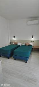 two beds in a room with blue beds at Sienda Cesira in Muravera
