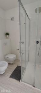 a bathroom with a glass shower and a toilet at Sienda Cesira in Muravera
