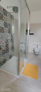 a bathroom with a glass shower and a toilet at Sienda Cesira in Muravera