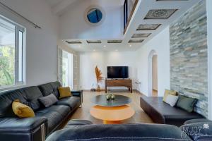ein Wohnzimmer mit einem Sofa und einem Tisch in der Unterkunft VILLA KELOHA - Luxueuse villa créole in L'Étang-Salé-les-Bains