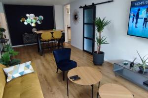 a living room with a couch and a table at Calme - Bien équipé - Parking -Terrasse in Pau