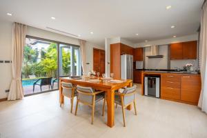 a kitchen and dining room with a wooden table and chairs at Villa Autjima krabi /3BRD in Ban Khlong Haeng