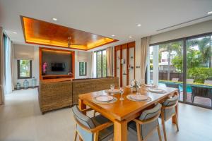 a dining room with a wooden table and chairs at Villa Autjima krabi /3BRD in Ban Khlong Haeng