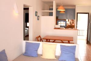 a living room with blue and white pillows and a table at Apartamentos Posidonia in Son Parc