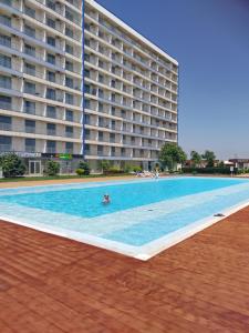 a large swimming pool in front of a large building at BLAXY Resort STEFI in Douăzeci şi Trei August