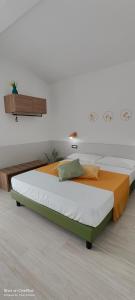 a bed in a room with a white wall at Sienda Cesira in Muravera