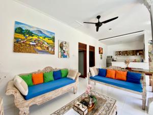 a living room with two blue couches at Timaya Villa in Legian