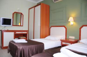 a hotel room with two beds and a tv at PİGALE BEACH RESORT in Kuşadası
