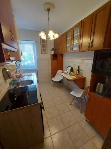 a kitchen with wooden cabinets and a table and chairs at City Comfort in Dunaújváros