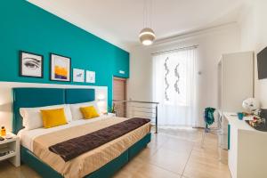 1 dormitorio con 1 cama grande y pared azul en Anima Rooms Apartments, en Sciacca