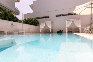 - une piscine avec des chaises et un parasol dans l'établissement La Gemma del Salento, à Racale