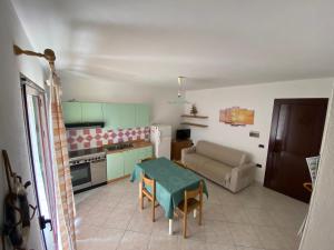 una cucina e un soggiorno con tavolo e divano di Villetta a 50 metri dal mare a Porto Ottiolu