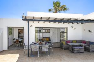 un patio con mesa, sillas y sofá en Villa Dulce Vista Costa Papagayo with Large Heated Private Pool & Air conditioning, en Playa Blanca