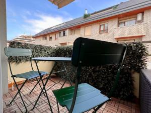 2 Stühle und ein Tisch auf der Terrasse in der Unterkunft Acogedor apartamento en Somo in Somo
