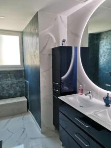een badkamer met een wastafel, een spiegel en een bad bij Marina dream in Toulon