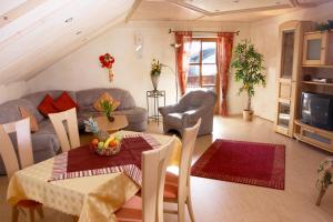 a living room with a table and a couch at Pension / Ferienwohnungen Ludwig in Rimbach