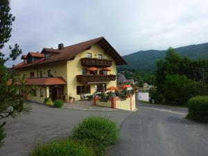 ein großes gelbes Gebäude mit orangefarbenen Sonnenschirmen auf einer Straße in der Unterkunft Pension / Ferienwohnungen Ludwig in Rimbach