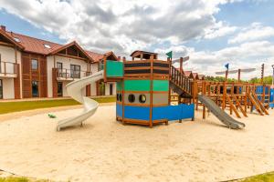 a playground with a slide in the sand at ŁEBSKA OSTOJA APARTAMENT LUKSUSOWY in Żarnowska