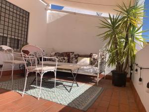 a room with a bed and chairs and a couch at Sierpes 50 in Seville