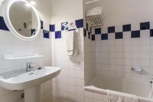 a white bathroom with a sink and a tub and a mirror at Apartamentos Las Pérgolas in Son Parc +13 photos