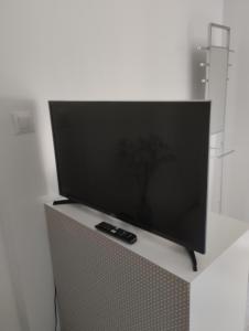 a flat screen tv sitting on top of a cabinet at Studio jardin in Aubenas