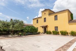 a large yellow house with a large courtyard at Agriresort Tenuta Macchiacupa in Ariano Irpino