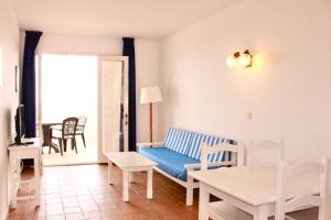 a living room with a couch and a table at Apartamentos Las Pérgolas in Son Parc