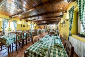 a restaurant with green tables and chairs and wooden ceilings at Agriresort Tenuta Macchiacupa in Ariano Irpino