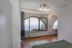 1 dormitorio con ventana grande con vistas al océano en Amiâ o Mâ by Wonderful Italy en Génova