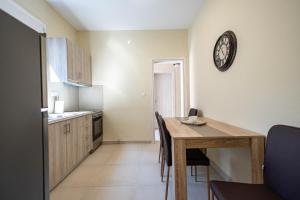 a kitchen and dining room with a table and a clock at Villa Saitan Bazaar in Preveza