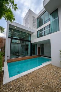 - une vue sur l'extérieur d'une maison avec une piscine dans l'établissement Poolvilla Near Nimmanheim - KING BED 3BR, à Chiang Mai