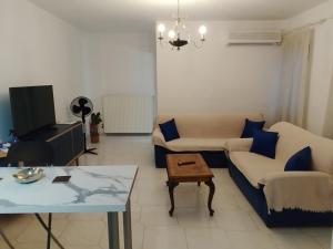 een woonkamer met een bank en een tafel bij Η Ελπίδα και η Γιάννα ξεκίνησαν ένα χώρο cute in Volos