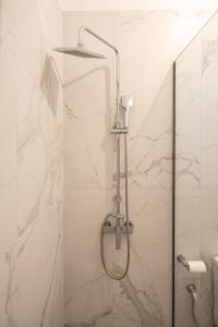 a shower in a bathroom with white marble walls at Villa Saitan Bazaar in Preveza