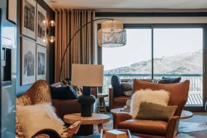 sala de estar con muebles y ventana grande en Luxury Alpine Apartment in the Centre Of It All en Mount Hotham