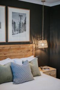 1 dormitorio con 1 cama con almohadas y lámpara en Luxury Alpine Apartment in the Centre Of It All en Mount Hotham