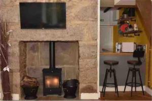 a fireplace with a television and a fire place at 3 bedroom cottage with hot tub and stunning views in Conwy