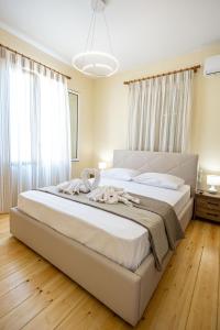 a bedroom with a large white bed with white curtains at Villa Saitan Bazaar in Preveza