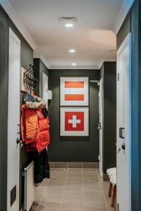 un pasillo con una pintura de cruz roja en la pared en Luxury Alpine Apartment in the Centre Of It All en Mount Hotham
