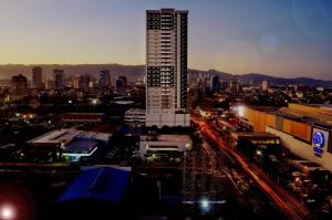 a city skyline with a tall building in the foreground at Sun Vida Tower Studio Unit Across SM City Cebu in Cebu City