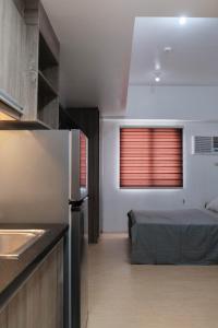 a room with a bed and a kitchen with a window at Sun Vida Tower Studio Unit Across SM City Cebu in Cebu City