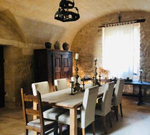 a dining room with a wooden table and chairs at Prieuré du 17è dans l'Ardèche méridionale in Vagnas