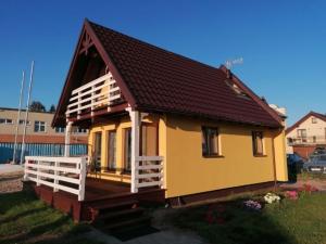 a small yellow house with a brown roof at Domki Grażyna in Jastarnia